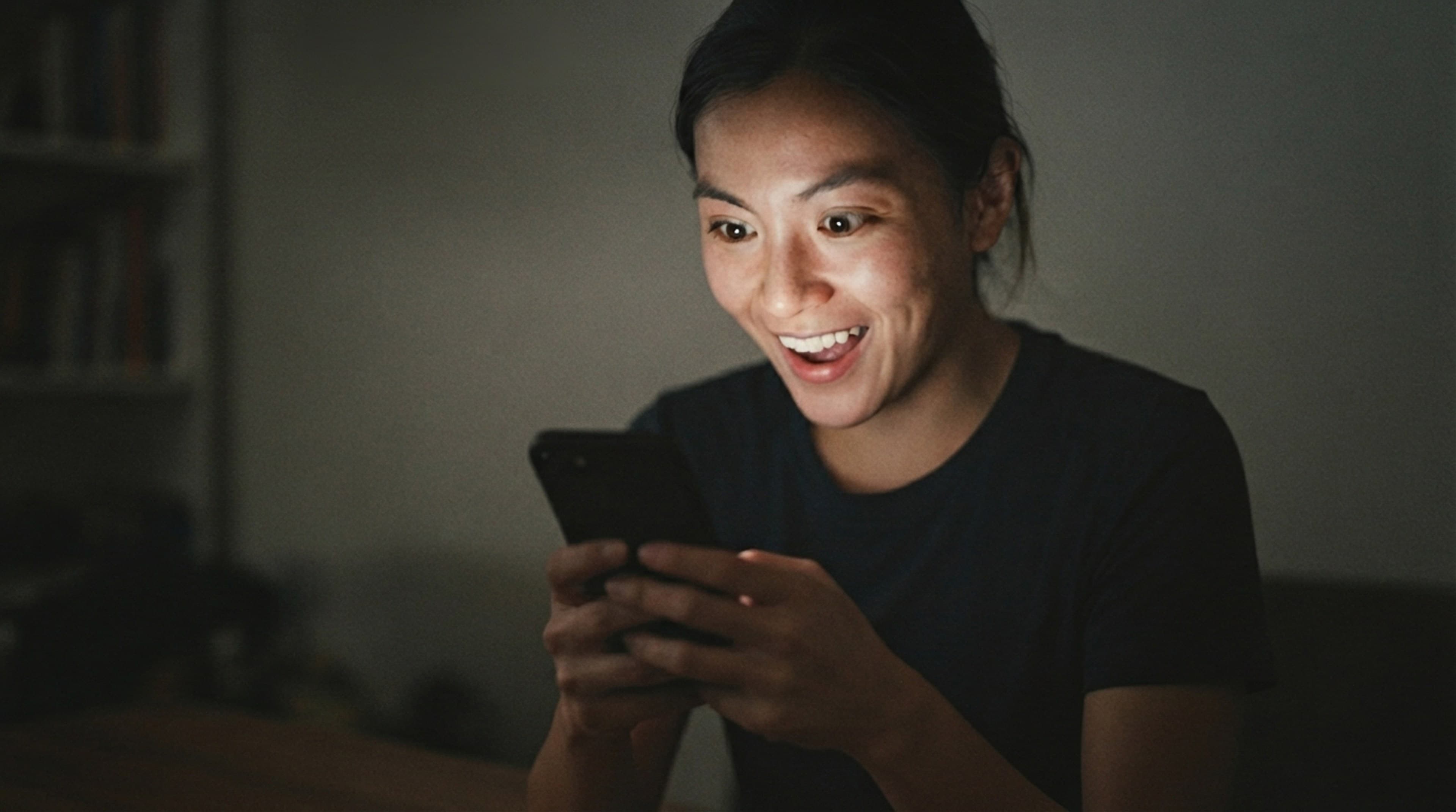 Someone smiling at their race photos on their phone